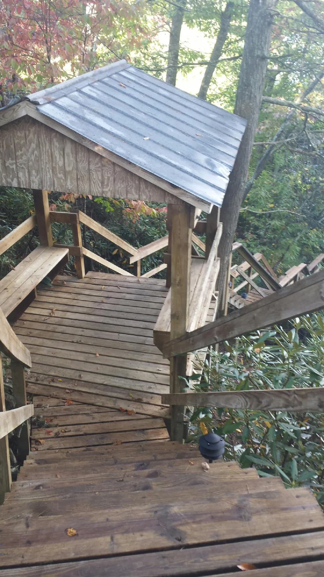 Metal roofed shelter over wooden steps on a wooded walkway — Skylight Repair & Installation work by our crew in Aultman