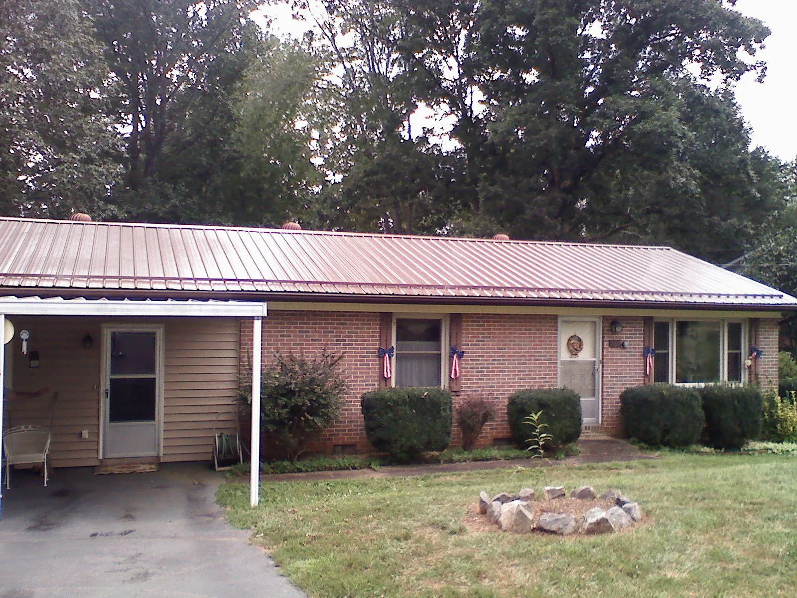 Bronze metal roof and carport on a brick ranch home — Roof Repair work by our crew in Aultman